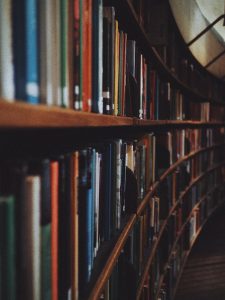 Warm-toned image of curved library bookshelves filled with books in Stockholm.